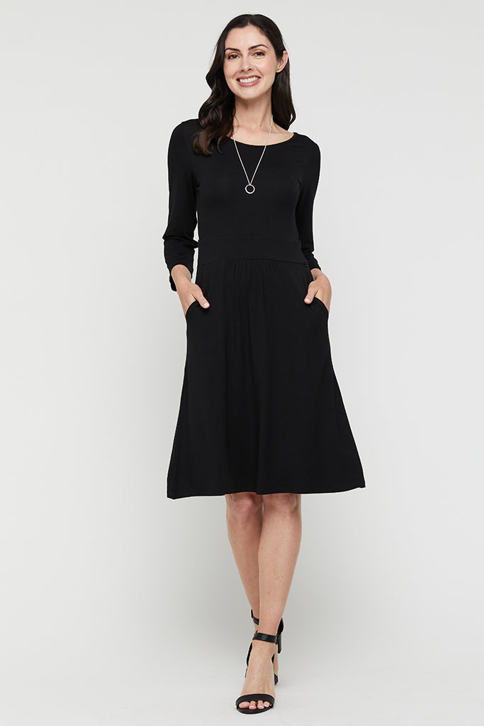 Knee length bamboo dress in black paired with black heels.