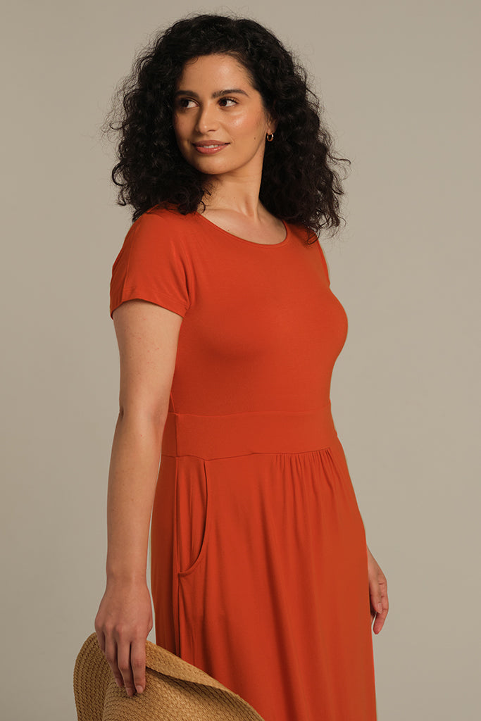Close up of orange bamboo dress featuring round, scoop neck and side pockets.