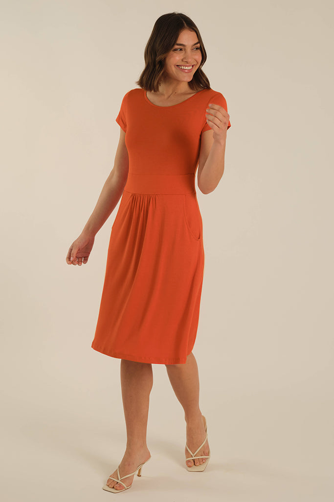 Model wearing a bright orange bamboo dress with a round neckline and short sleeves.