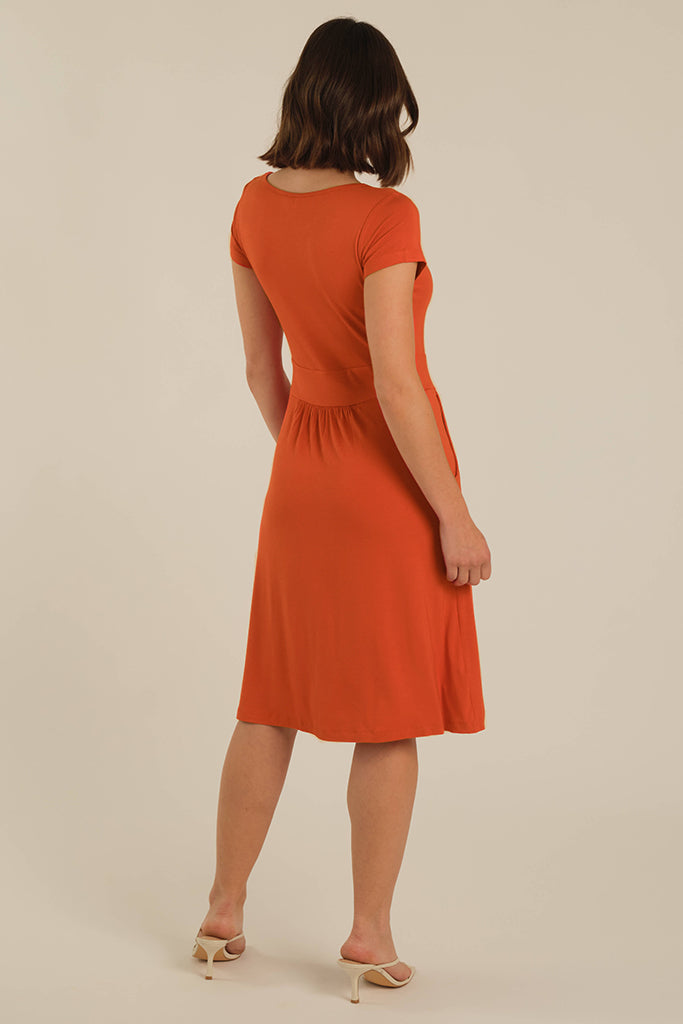 Back view of knee length dress in orange.