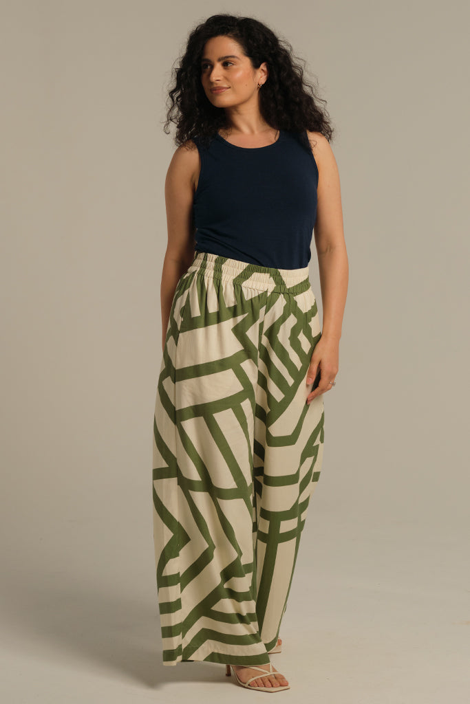 Model is wearing a fitted dark navy Bobby Singlet paired with wide leg pants for a casual look