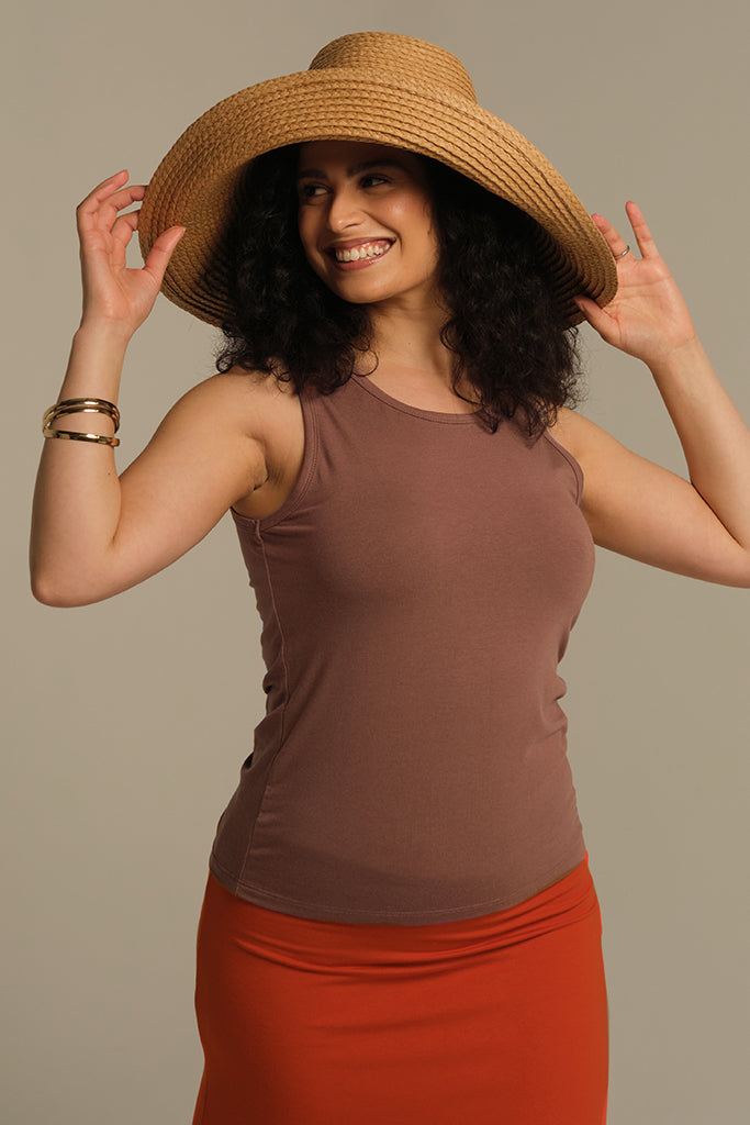 Sleeveless singlet with thick shoulder straps for good sun coverage paired with an orange skirt and a straw hat for summer vibes.