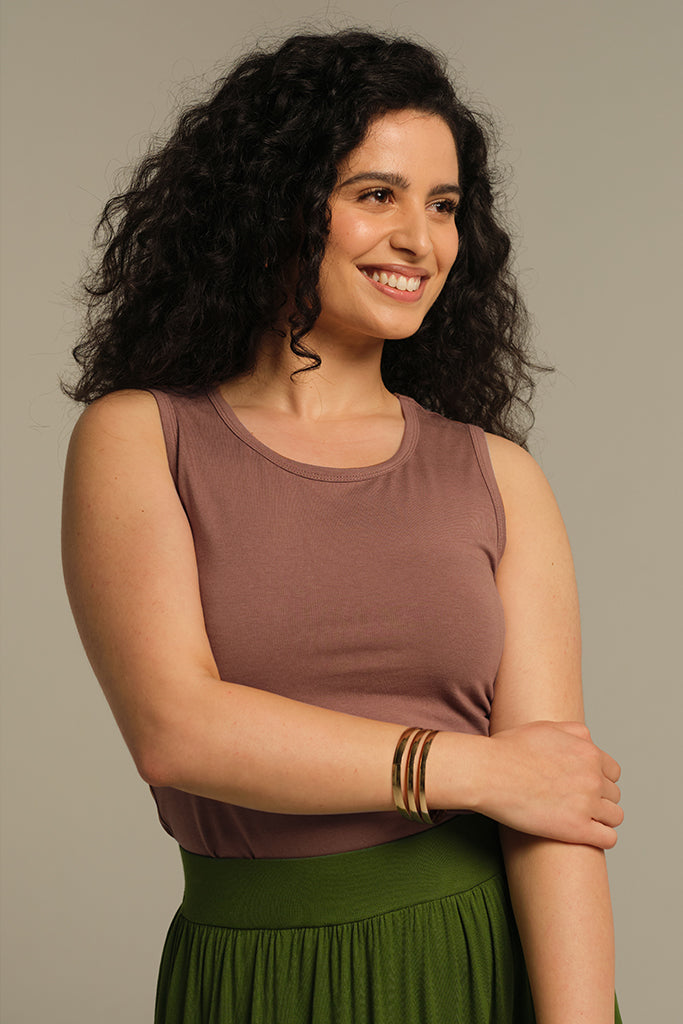 Model wearing high neckline and snug fit. Can be worn just on it's own in summer or as a winter warmer under a long sleeve top.