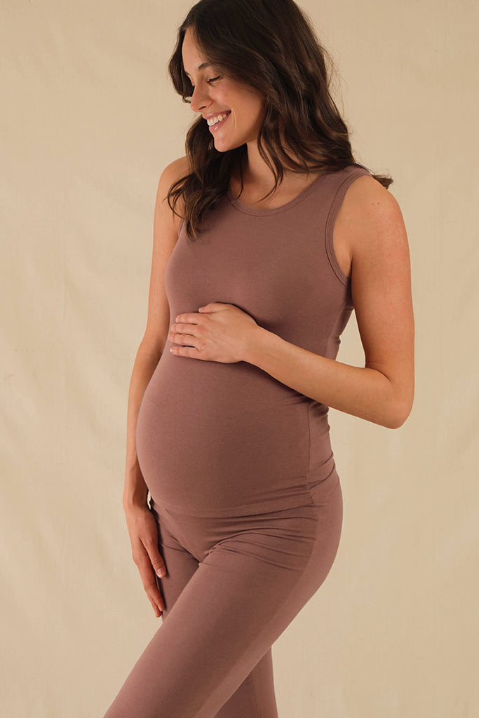 Pregnant model wearing fitted brown soft bamboo singlet covering her baby belly.