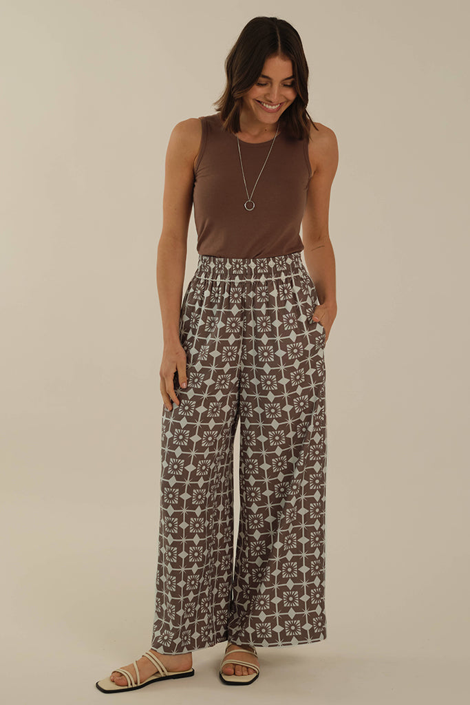 Fitted brownish versatile trans-seasonal singlet tucked into wide woven pants for a casual relaxed look.
