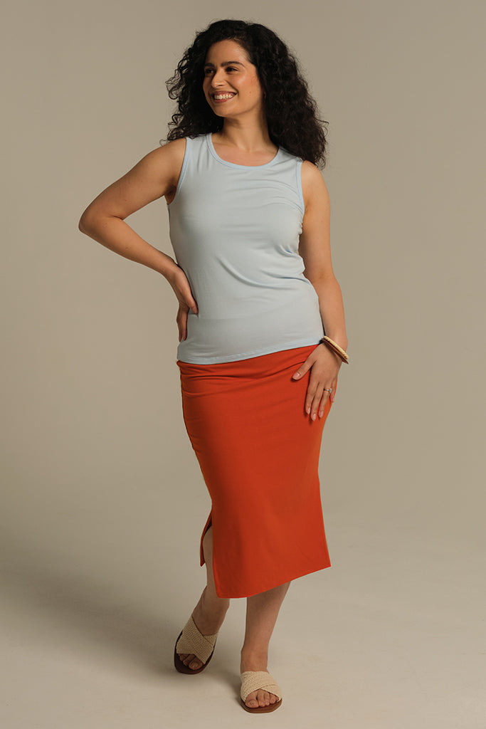 Model wearing sky blue wide strap tank top paired with orange pencil skirt ready for her day in the office.