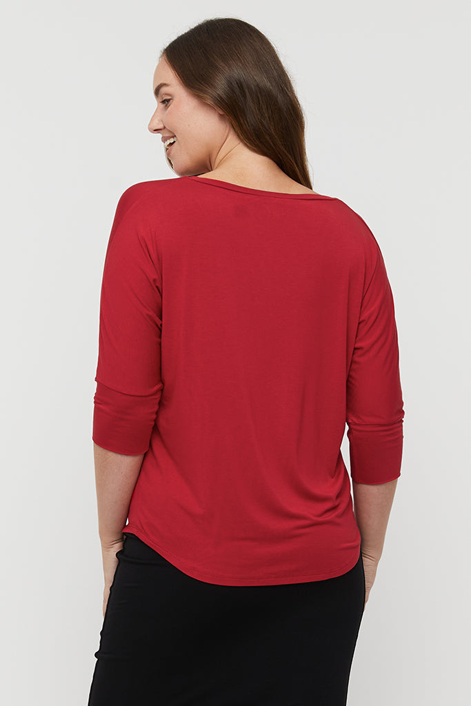 Back view of model wearing a comfortable red bamboo tee with dolman cuffed sleeves.