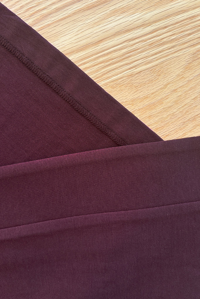 Close-up of burgundy bamboo fabric on a wooden surface
