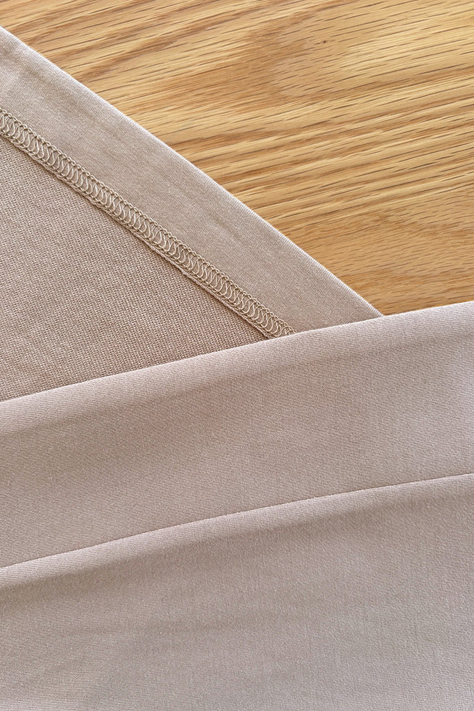 Close-up of beige bamboo fabric with a wooden surface in the background