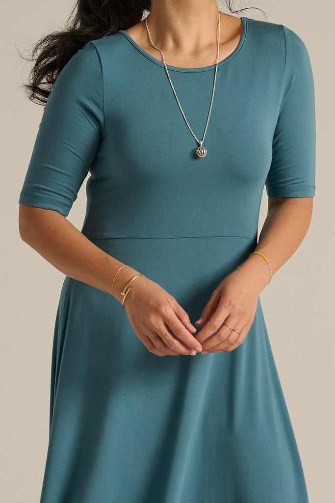 Closeup of bamboo midi dress in blue, featuring round neckline.