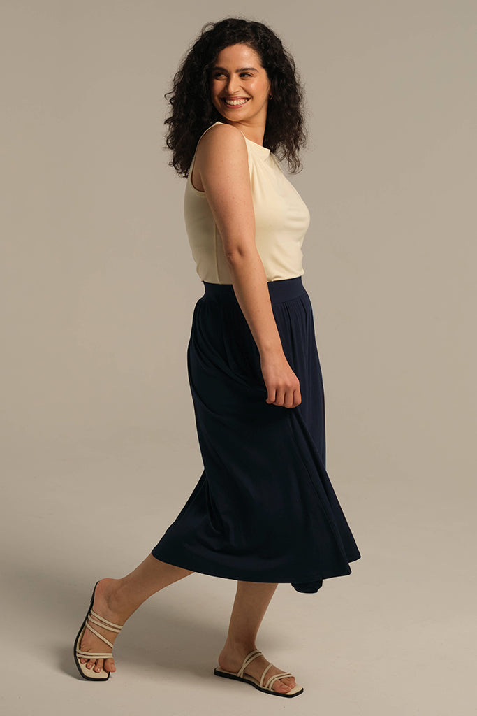 Model wearing navy midi skirt and cream tank top