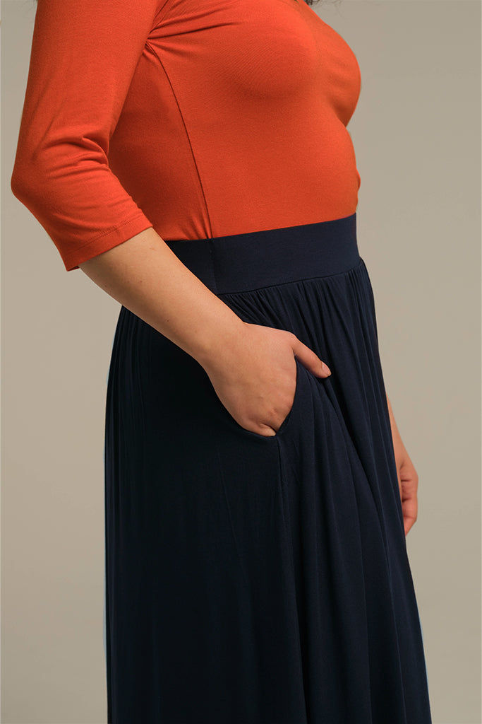 Close-up of waistband, pockets and pleats on navy midi skirt
