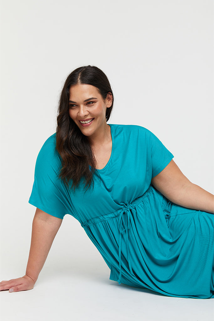 Closeup of the maxi plus size dress in teal, featuring a scoop neckline.