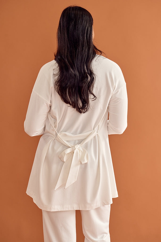 Back view of model wearing a white bamboo cardigan with an adjustable belt.