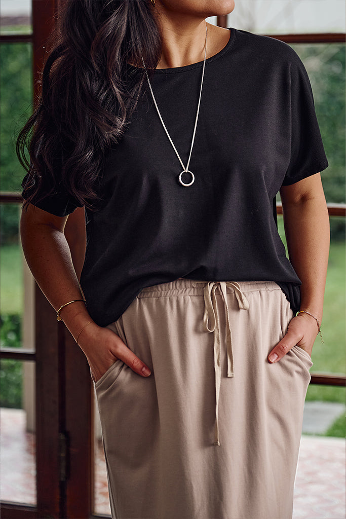 Closeup of model wearing a black bamboo tee featuring elegant coverage and classic short sleeves.