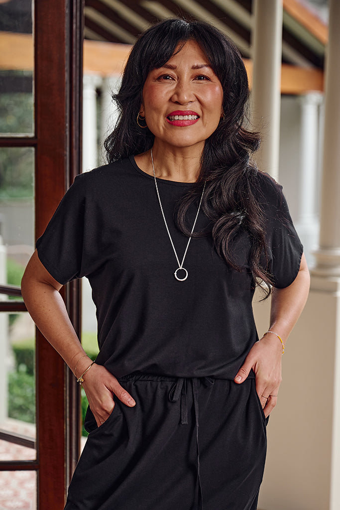 Closeup of older model wearing a thick bamboo black tee with short sleeves and a relaxed fit.