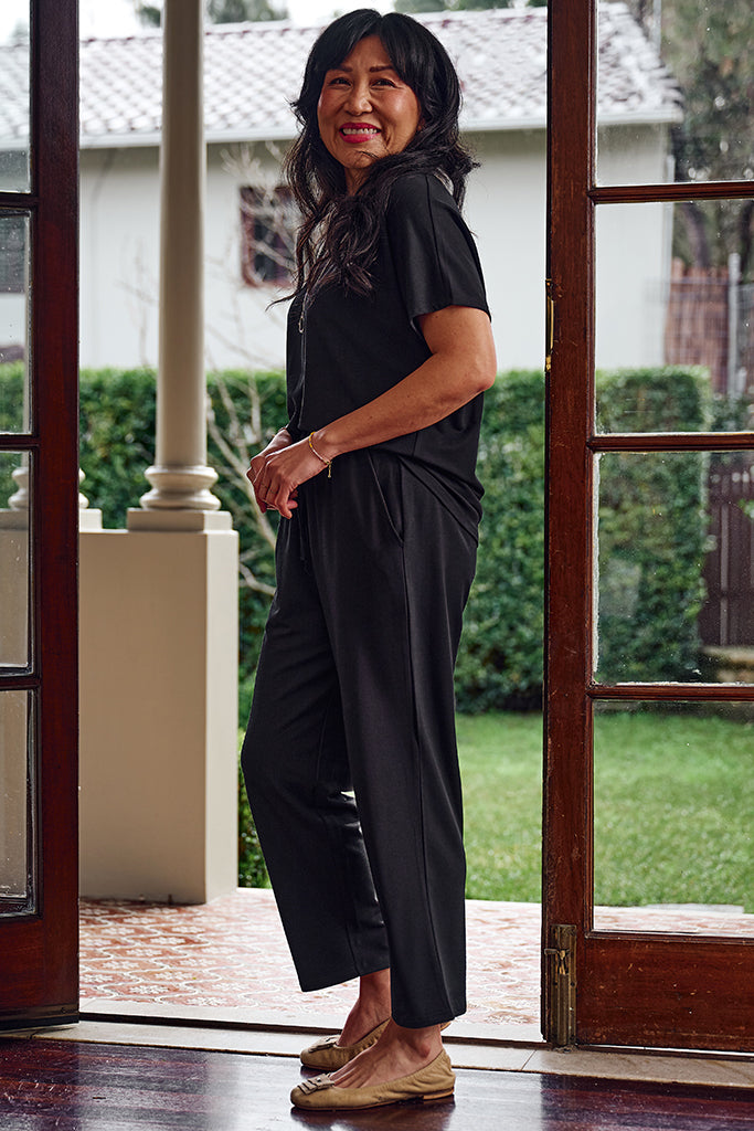 Side view of model wearing a black bamboo tee and matching pants.