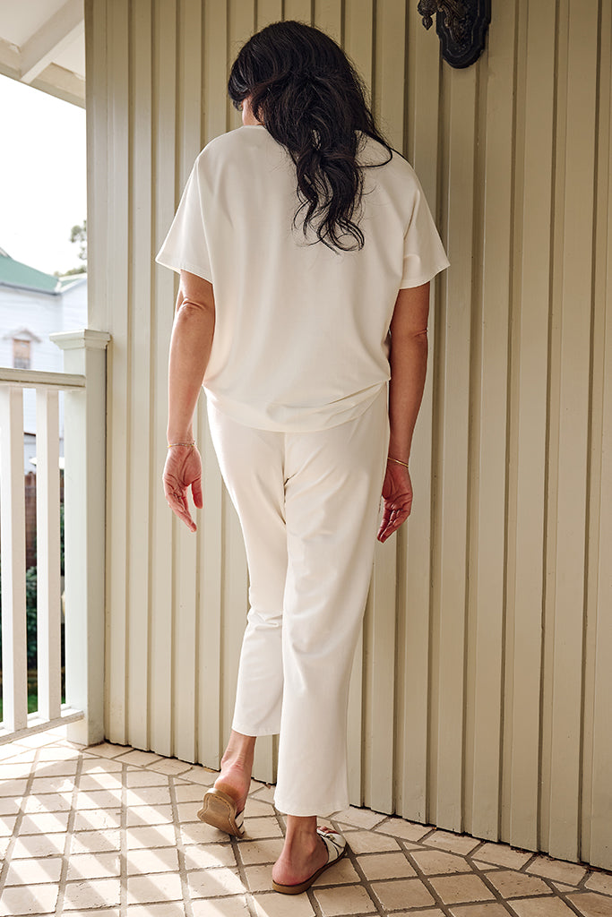 Back view of model wearing a bamboo short sleeved tee and stretchy pants that are cropped at the ankle.