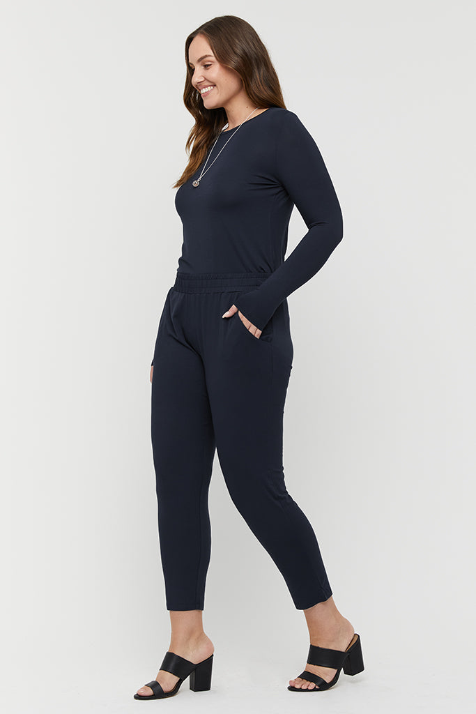 a woman wearing an outfit consisting of the dark navy Peggy trousers with a comfy elastic band and side pockets paired with the dark navy crew layering top with long sleeves