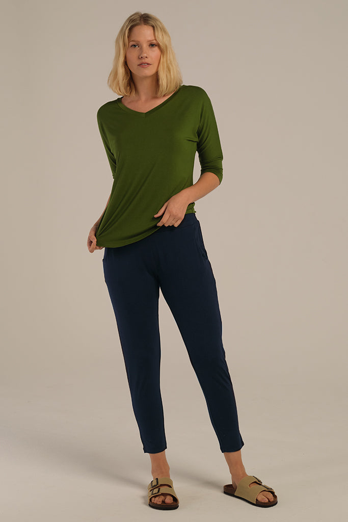 a woman wearing the dark navy Peggy pants with a tapered leg and side pockts