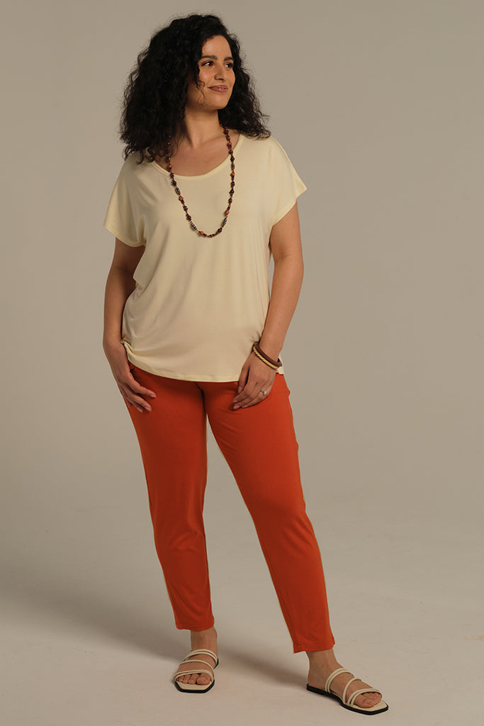 a woman wearing Peggy bamboo pants in flame colour with above the ankle length