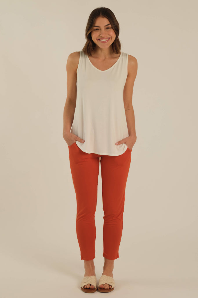 a model wearing the peggy bamboo pants with side pockets in an orange colourway