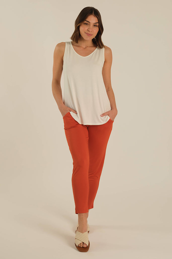 A model wearing tapered bamboo pants with side pockets paired with an ivory v-neck top