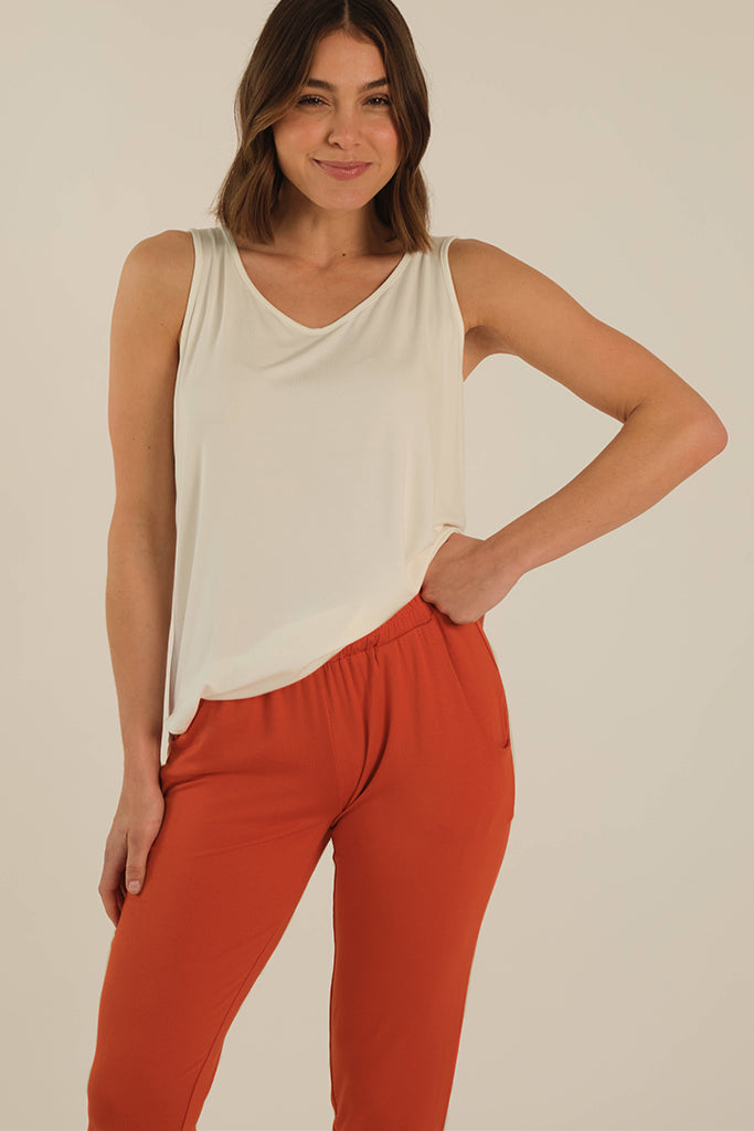 a close up view of the peggy pants in the flame colour featuring a stretchy elastic waistband and side pockets