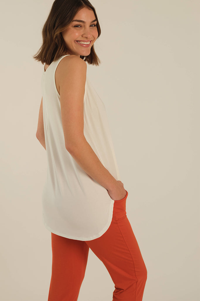 a back view of the paggy pants in orange with side pockets paired with an elongated tank top