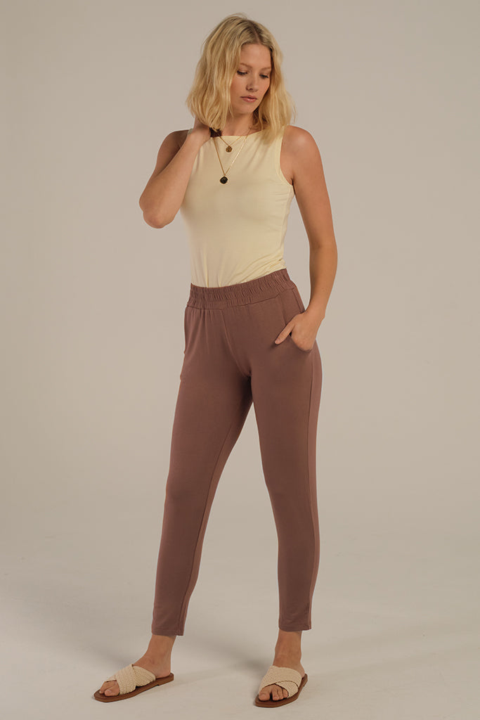 a model wearing the peggy bamboo pants with side pockets and a comfy stretchy waistband paired with the shell top in vanilla