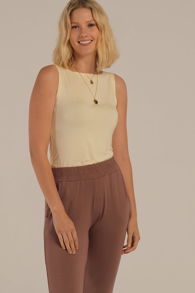 a model wearing the peggy bamboo pants with an elastic waistband paired with the shell top in vanilla