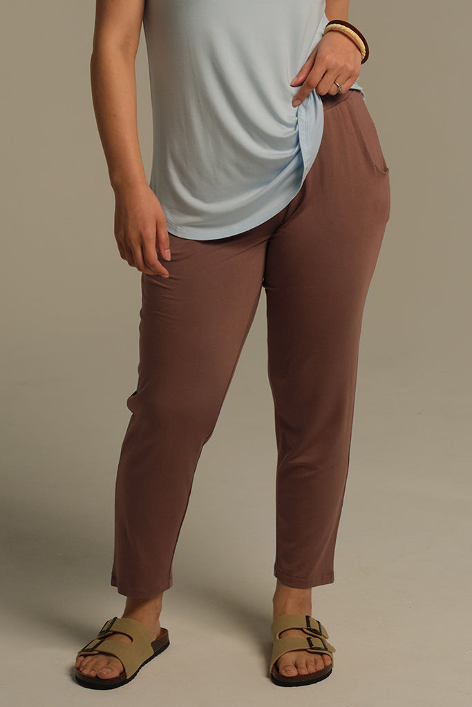 a model wearing peggy bamboo pants in mocha mousse colour showcasing the side pockets and an elastic band