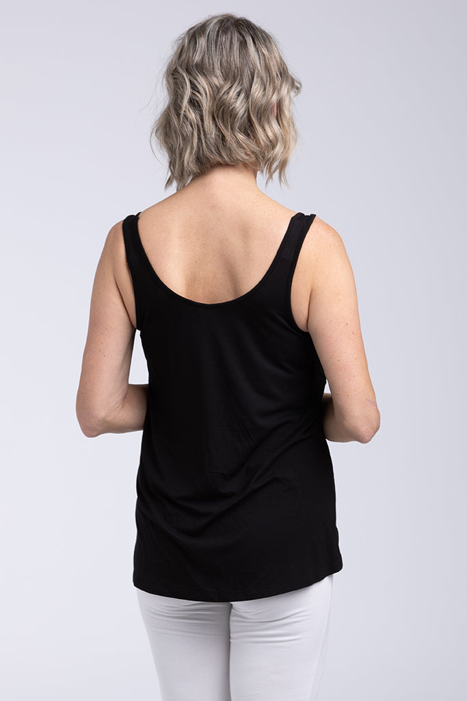 Back view of model wearing a black singlet and white pants