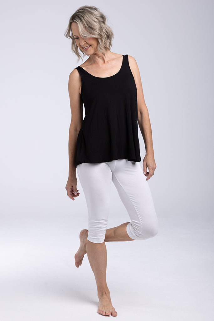 Barefoot model wearing a soft bamboo relaxed singlet with white 3/4 leggings.