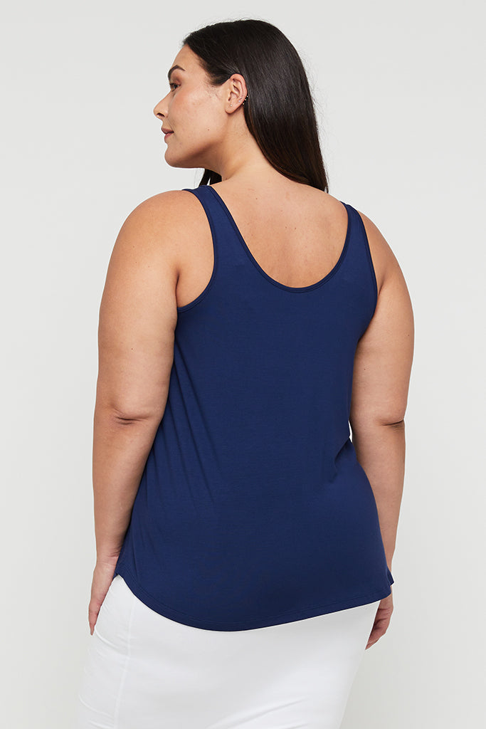 Model wearing navy shaded singlet with white skirt for a casual and easy outfit.