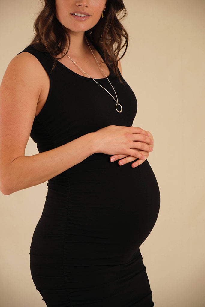 Close-up of black bamboo maternity dress showing detailed side ruching and soft texture