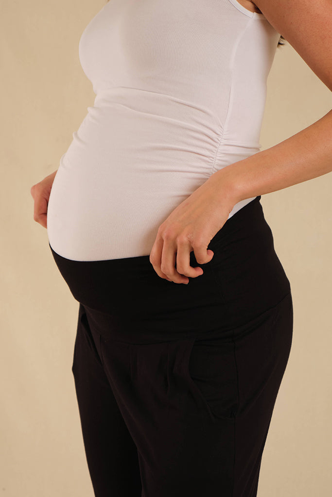 a close up view of the black bamboo slouch pants with soft and stretchy waistband shown on a pregnant belly