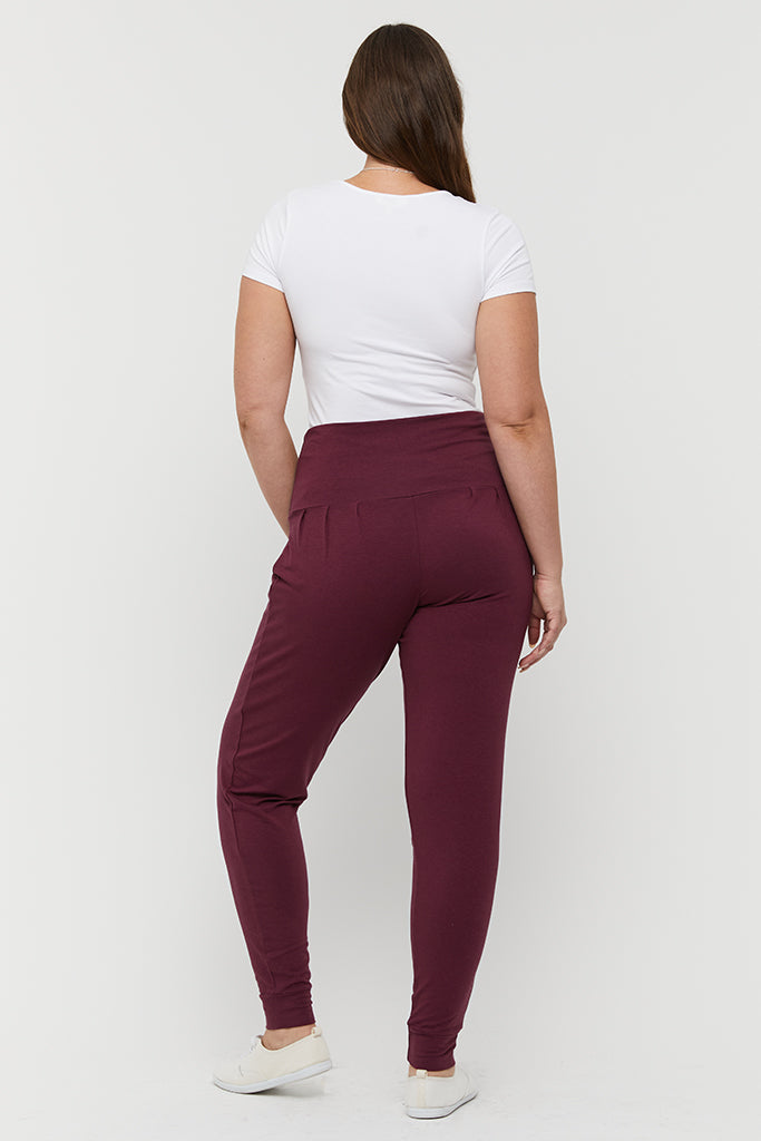 A back view of the bamboo slouch pants in burgundy featuring cuffed ankles and a soft stretchy waistband