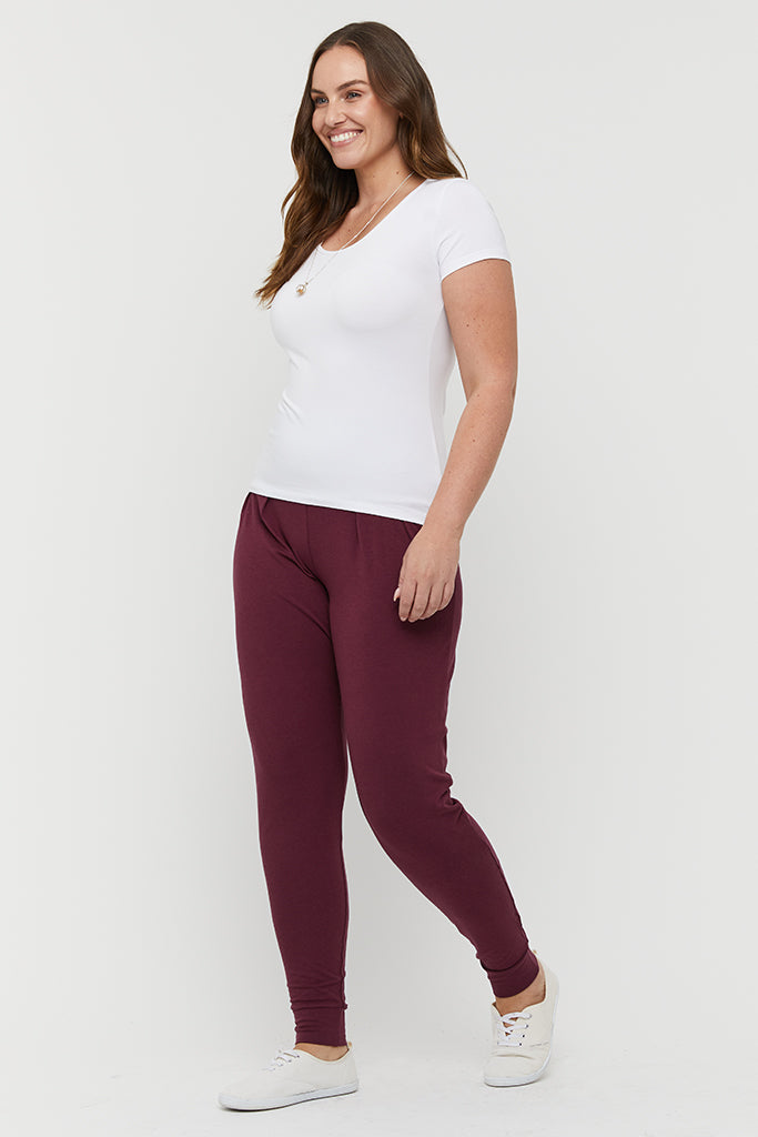 a side view of the slouch bamboo pants in burgundy colour featuring cuffed ankles