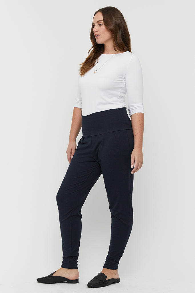 a side view of the dark navy bamboo slouch pants featuring a wide soft waistband and cuffed ankles