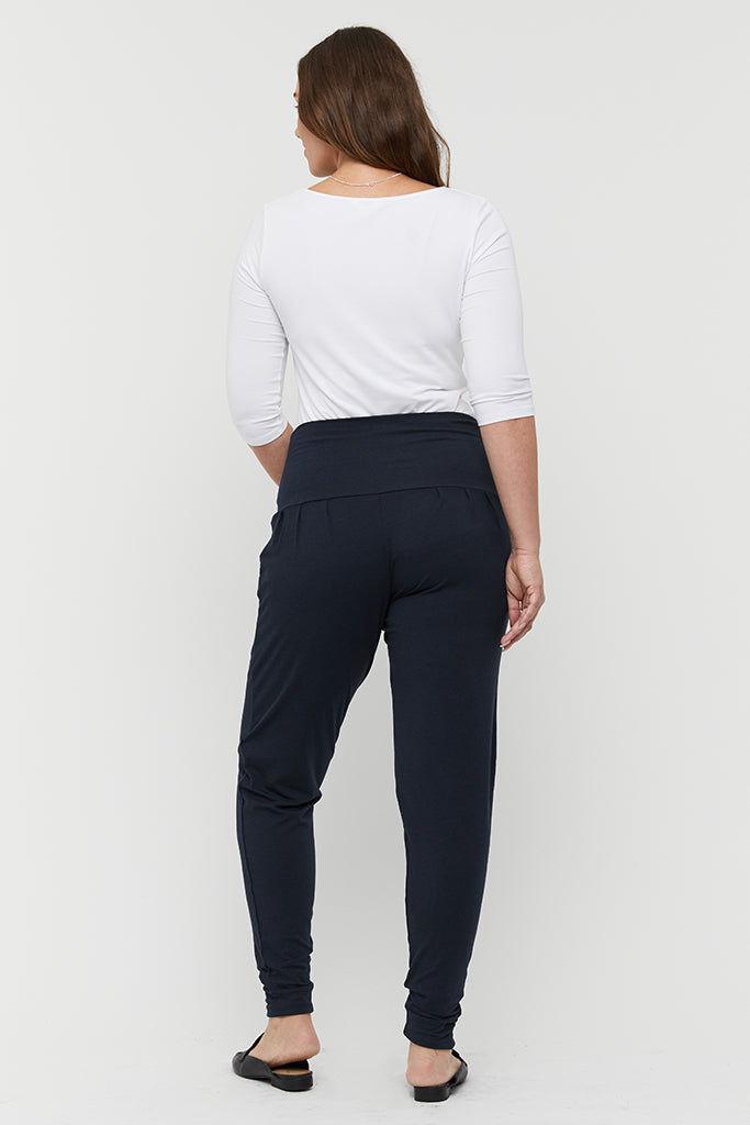 a back view of the bamboo slouch pants in dark navy shade featuring cuffed ankles and a high rise stretchy waistband