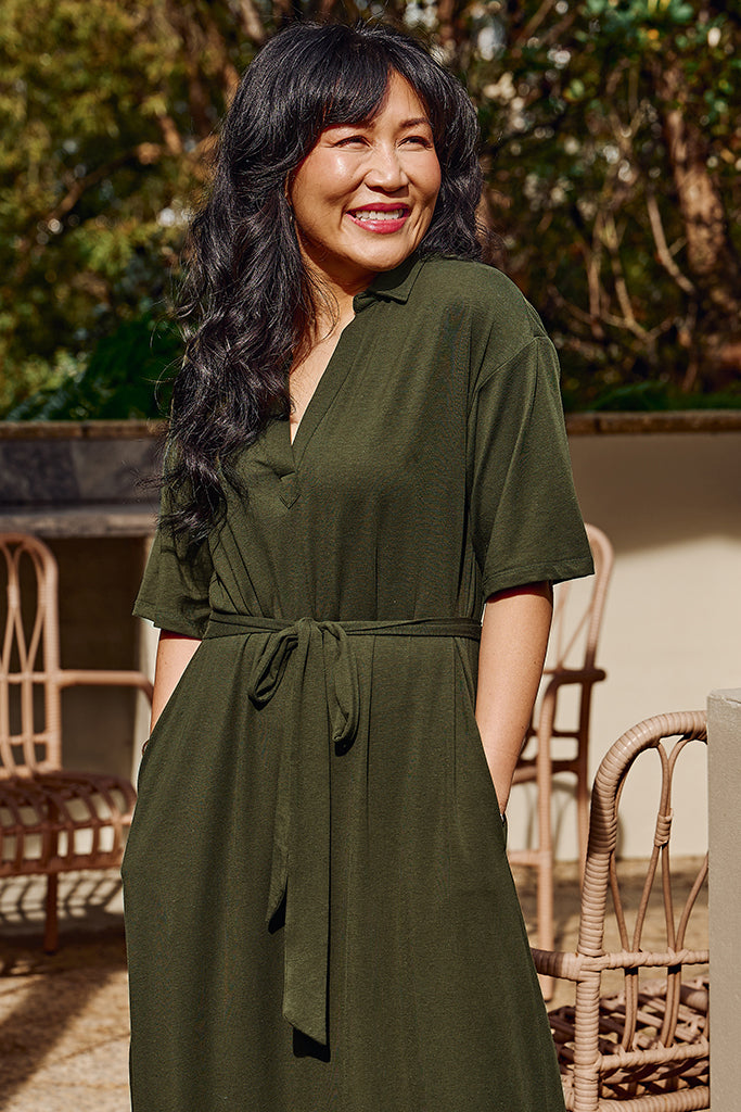 Close up of model wearing a moss green bamboo-linen dress with relaxed, flowy fit.