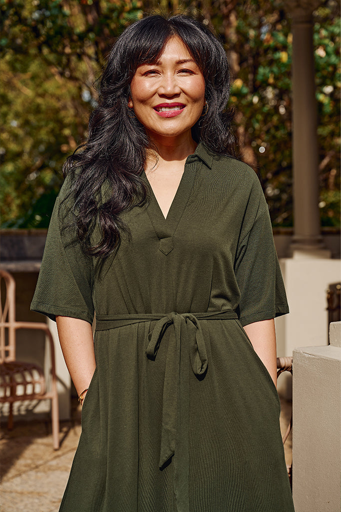 Close up of green bamboo linen maxi dress, featuring waist tie, side pockets and above elbow sleeves.