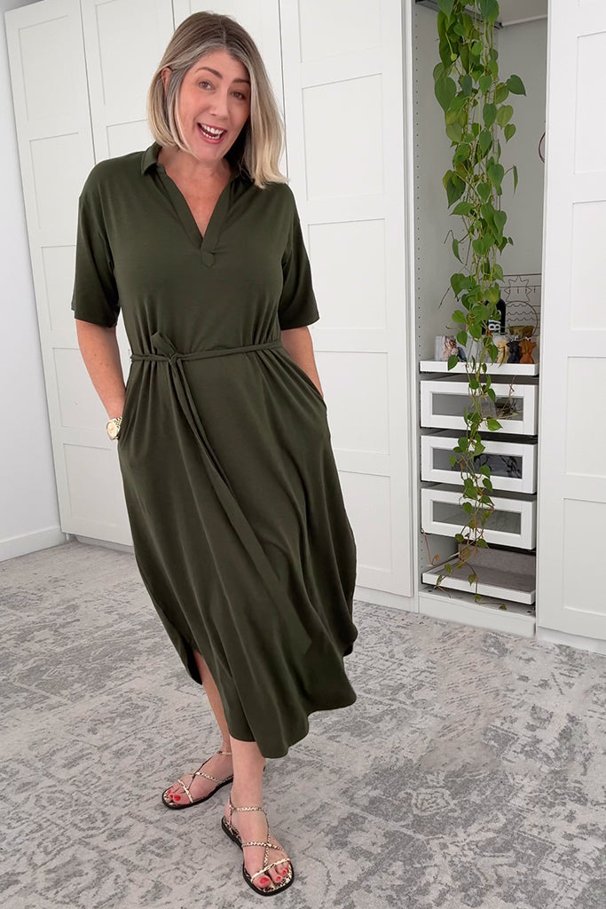 Model wearing a moss green dress with a tie around the waist.