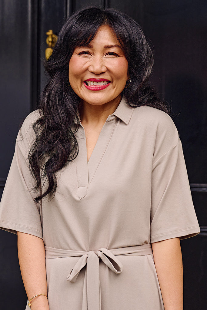 Close up of model wearing a taupe maxi dress made out of bamboo and organic cotton.