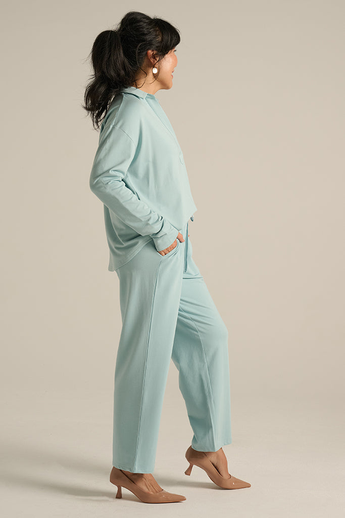 woman wearing an aquamarine pair of pants with a matching top