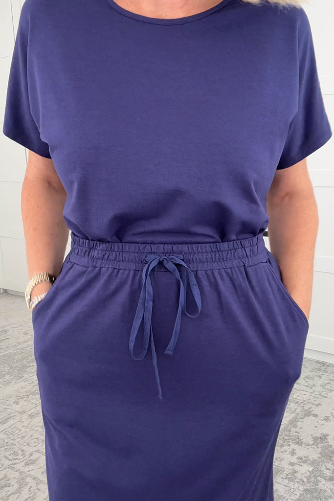 Closeup of model wearing a purple midi skirt made out of soft and sustainable bamboo fabric.