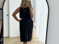 Video of model wearing black bamboo reversible dress with high neckline.