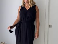 Video of model wearing a black reversible dress and a belt in heels.