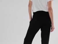 a model wearing the peggy bamboo pants featuring side pockets, an elasticated waistband and a tapered leg